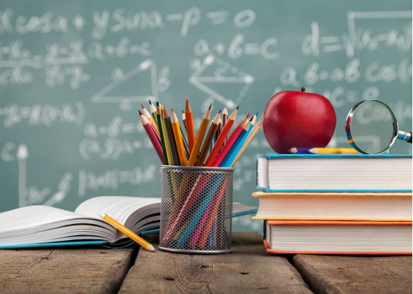 Desk with books, pencils, and a chalkboard